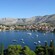 Sailboats moored in the water next to a mountainous seaside village